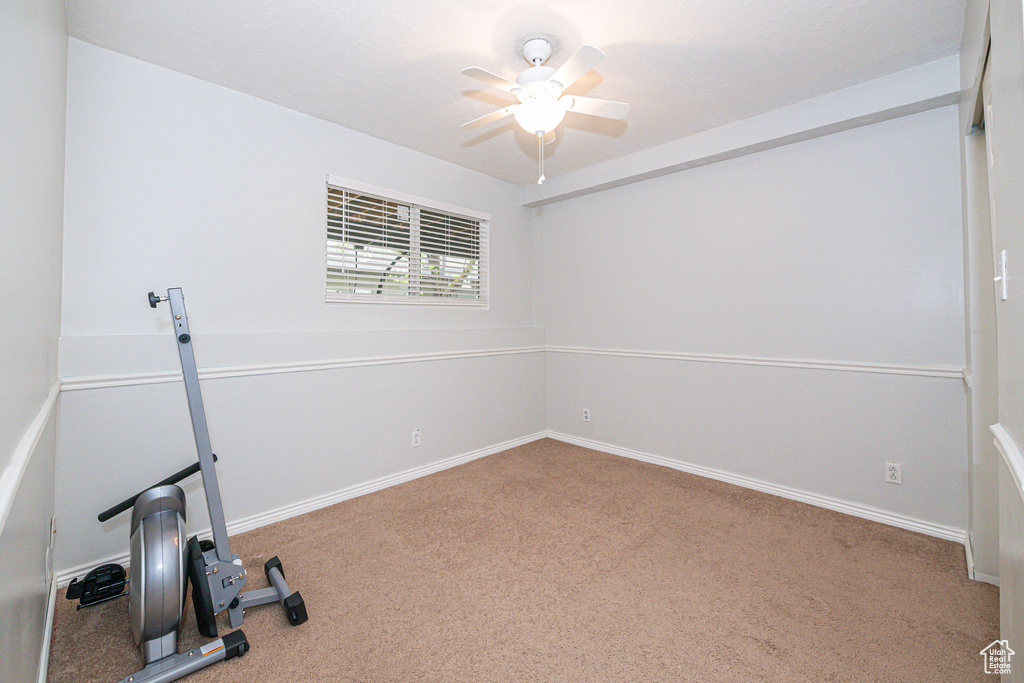 Workout room featuring light carpet and ceiling fan