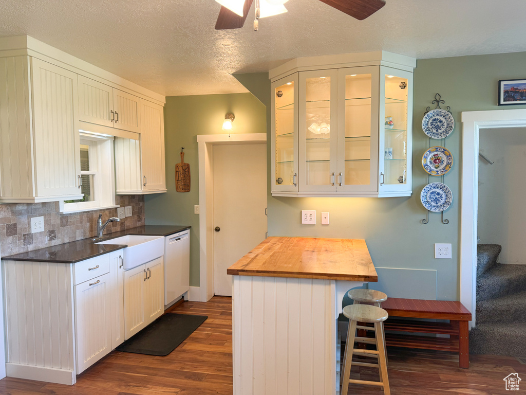 Kitchen featuring ceiling fan, white cabinets, sink, dishwasher, and dark hardwood / wood-style flooring
