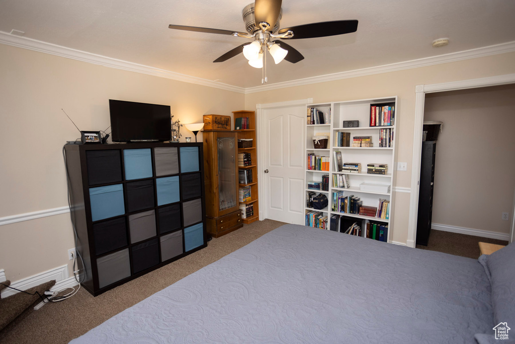 Carpeted bedroom featuring ceiling fan and ornamental molding