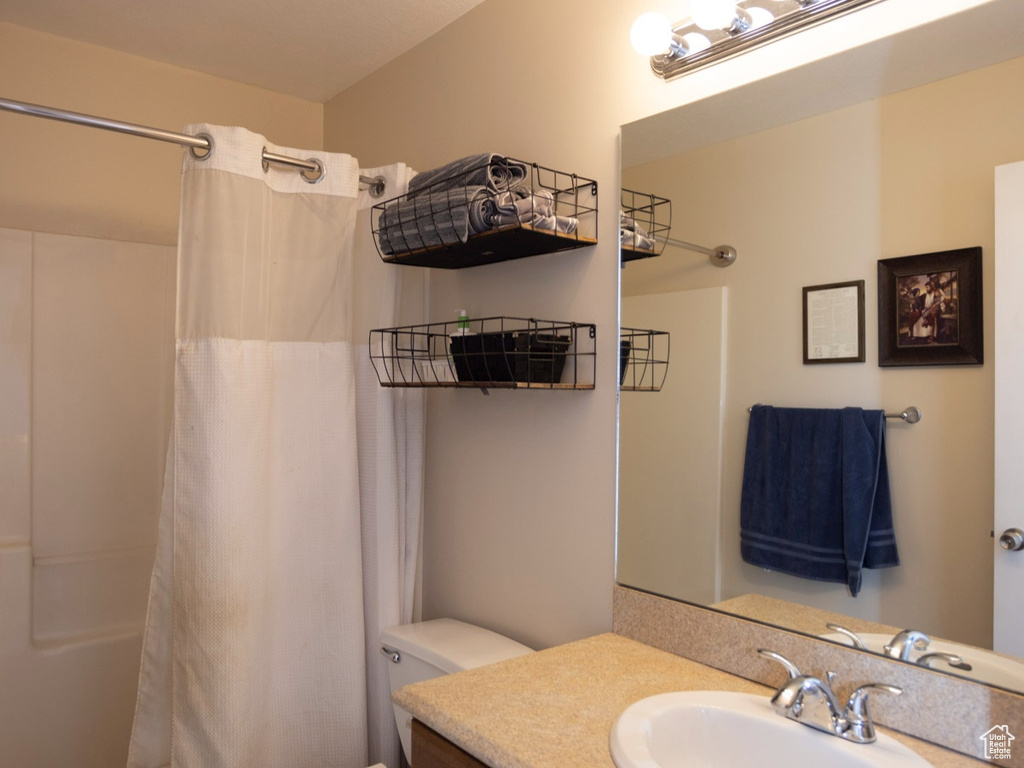 Full bathroom with tile floors, shower / tub combo, vanity, and toilet