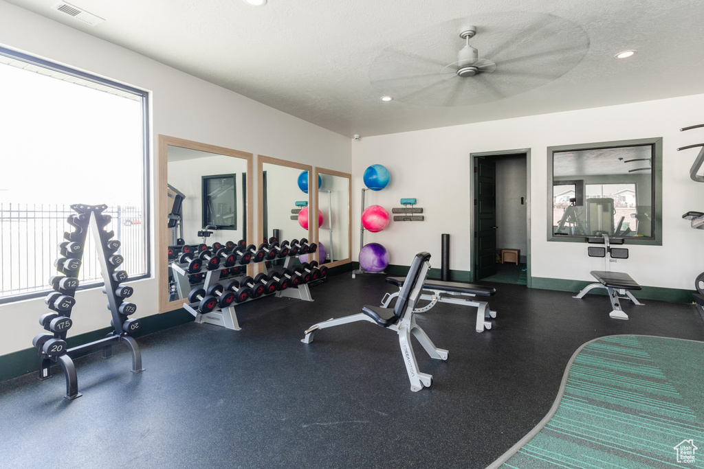 Exercise room featuring ceiling fan and a textured ceiling