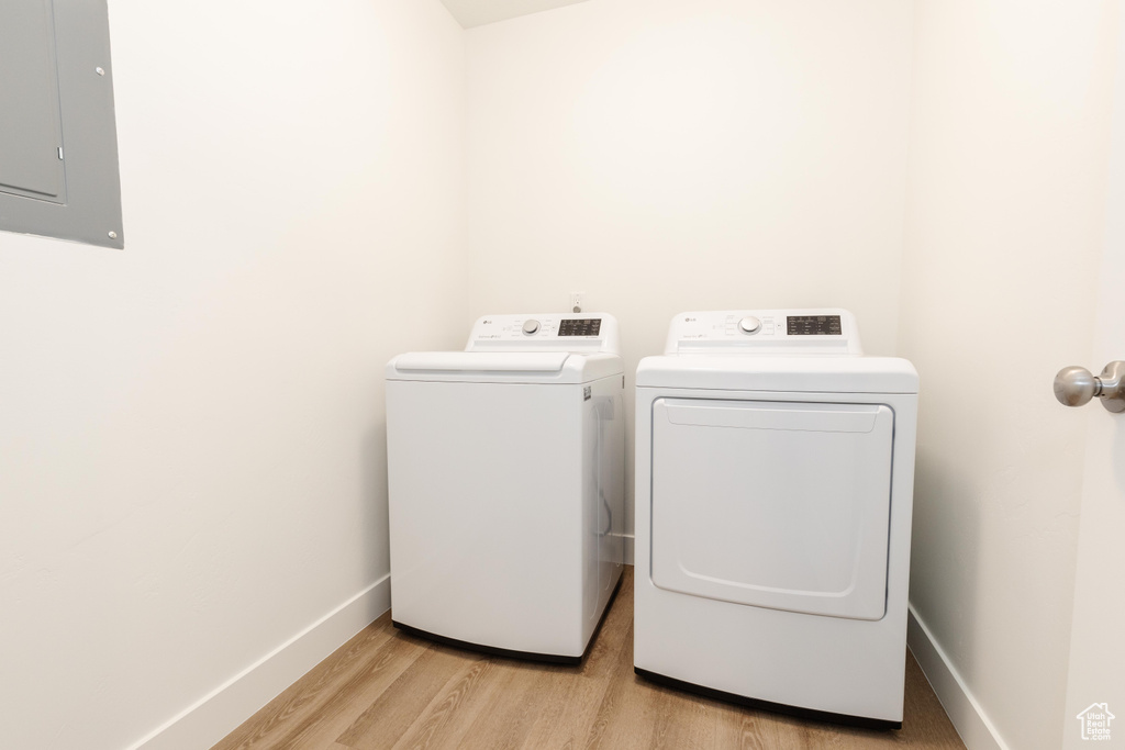Washroom featuring light wood-type flooring and washer and clothes dryer