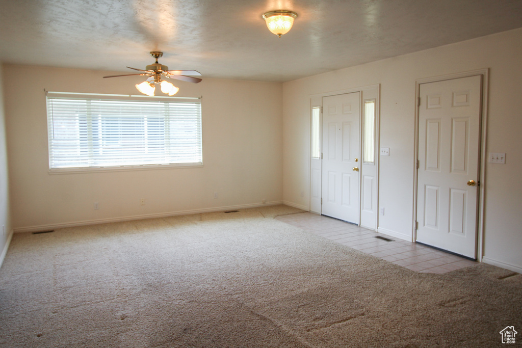 Unfurnished bedroom featuring light colored carpet and ceiling fan