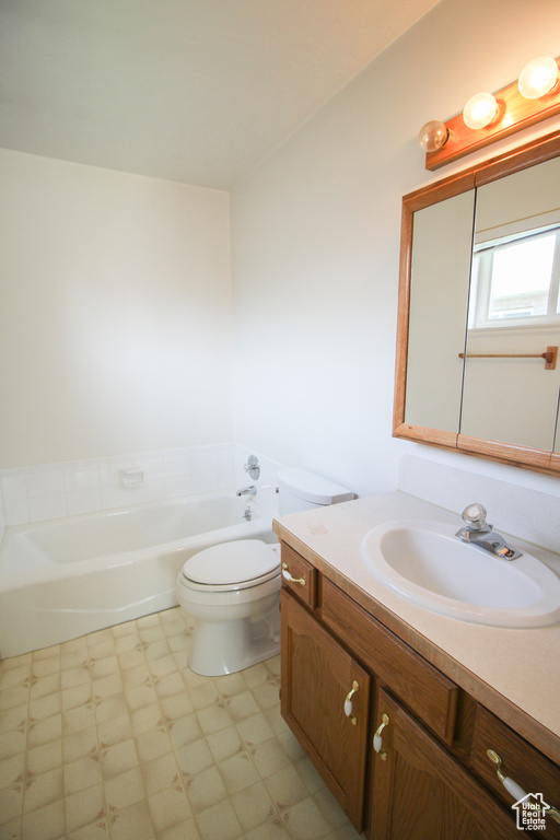 Bathroom featuring a bathing tub, vanity, toilet, and tile floors