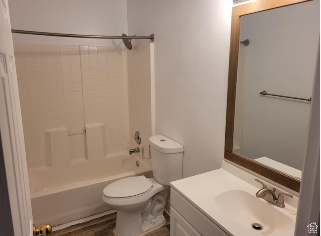 Full bathroom featuring shower / washtub combination, toilet, vanity, and hardwood / wood-style floors