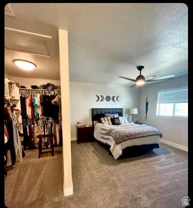 Bedroom featuring dark colored carpet, a closet, ceiling fan, and a textured ceiling