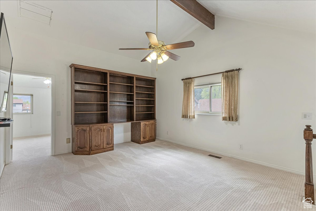 Unfurnished living room with high vaulted ceiling, light carpet, ceiling fan, and beam ceiling