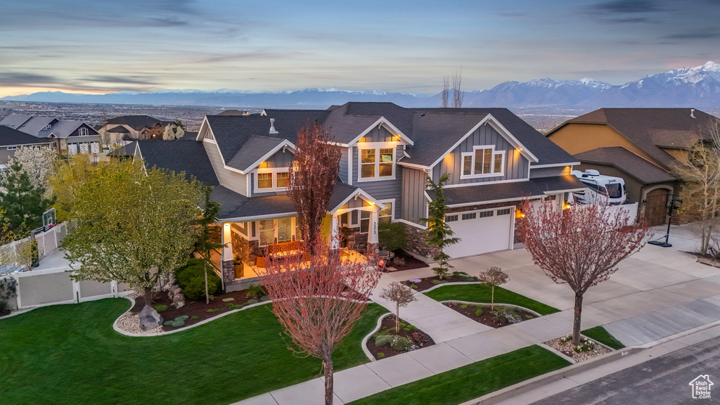 Craftsman inspired home featuring a mountain view, a yard, and a garage