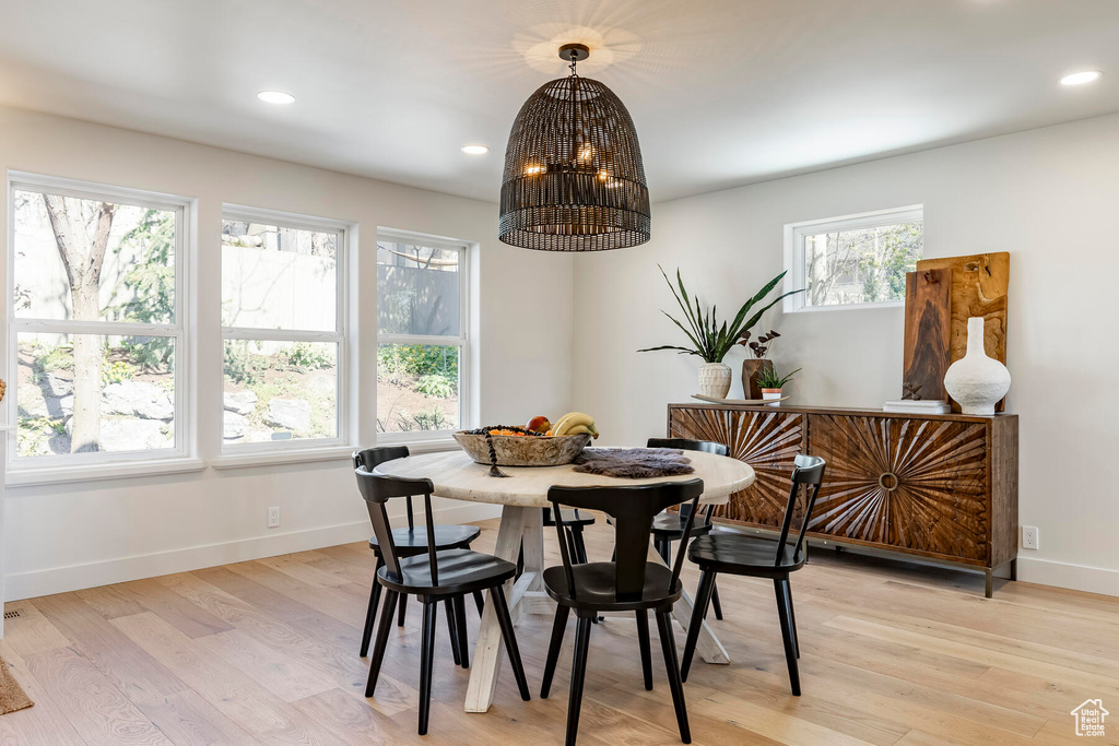Dining room with plenty of natural light, light hardwood / wood-style floors, and an inviting chandelier
