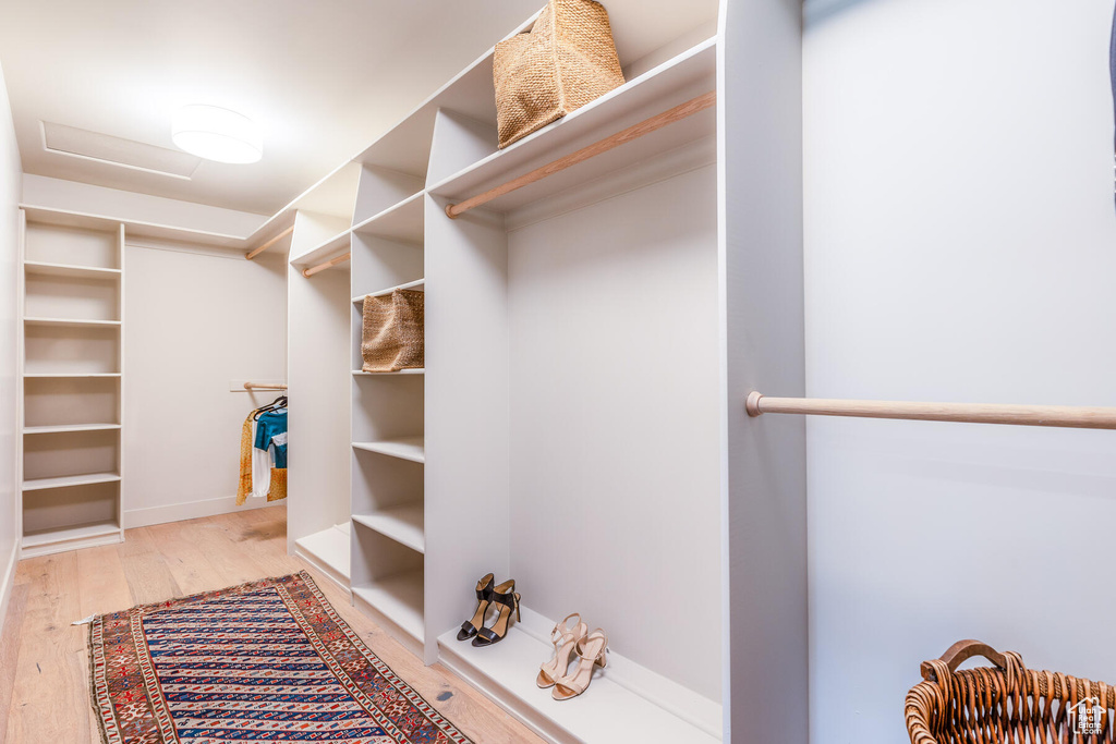 Spacious closet with light hardwood / wood-style flooring