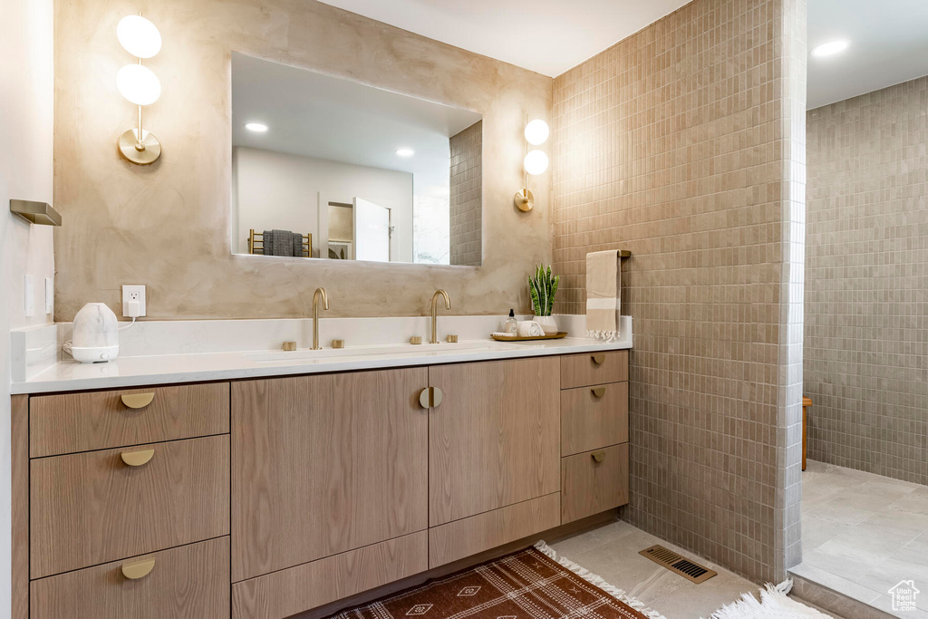 Bathroom with tile walls, vanity, and tile flooring