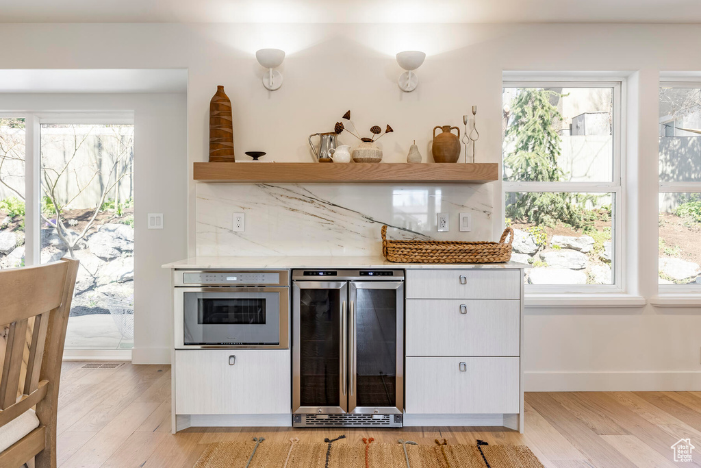 Kitchen with a wealth of natural light, light hardwood / wood-style flooring, and oven