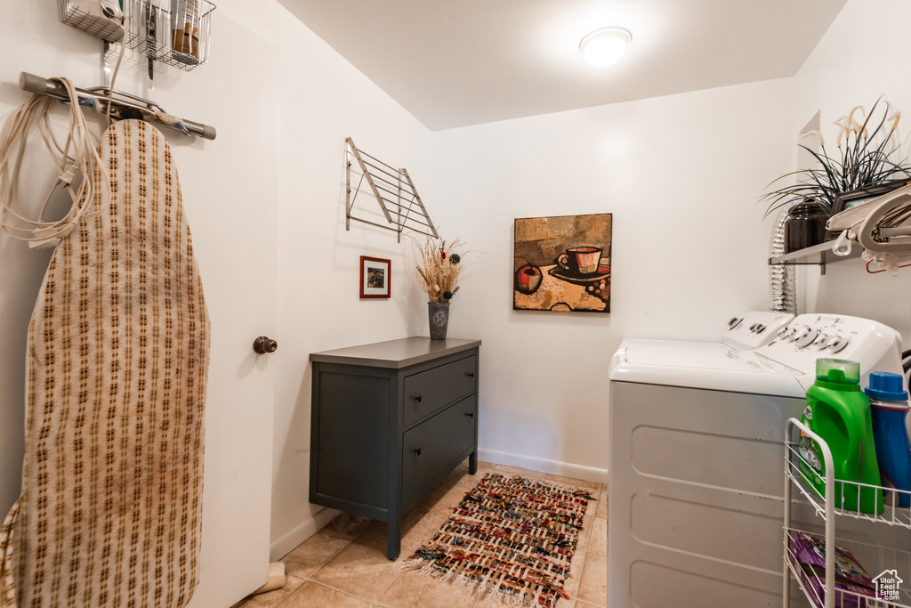 Laundry room with washing machine and dryer and light tile flooring