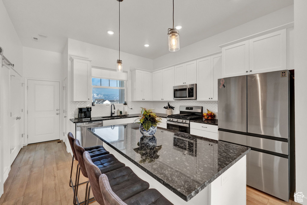 Kitchen with appliances with stainless steel finishes, tasteful backsplash, and a center island