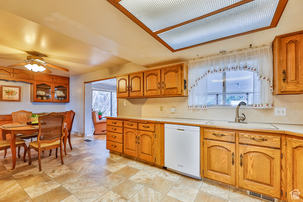 Kitchen with sink, ceiling fan, white dishwasher, and light tile floors