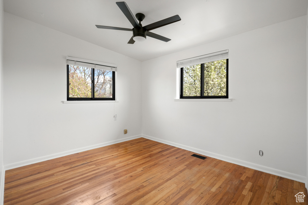 Spare room with vaulted ceiling, light hardwood / wood-style floors, and ceiling fan