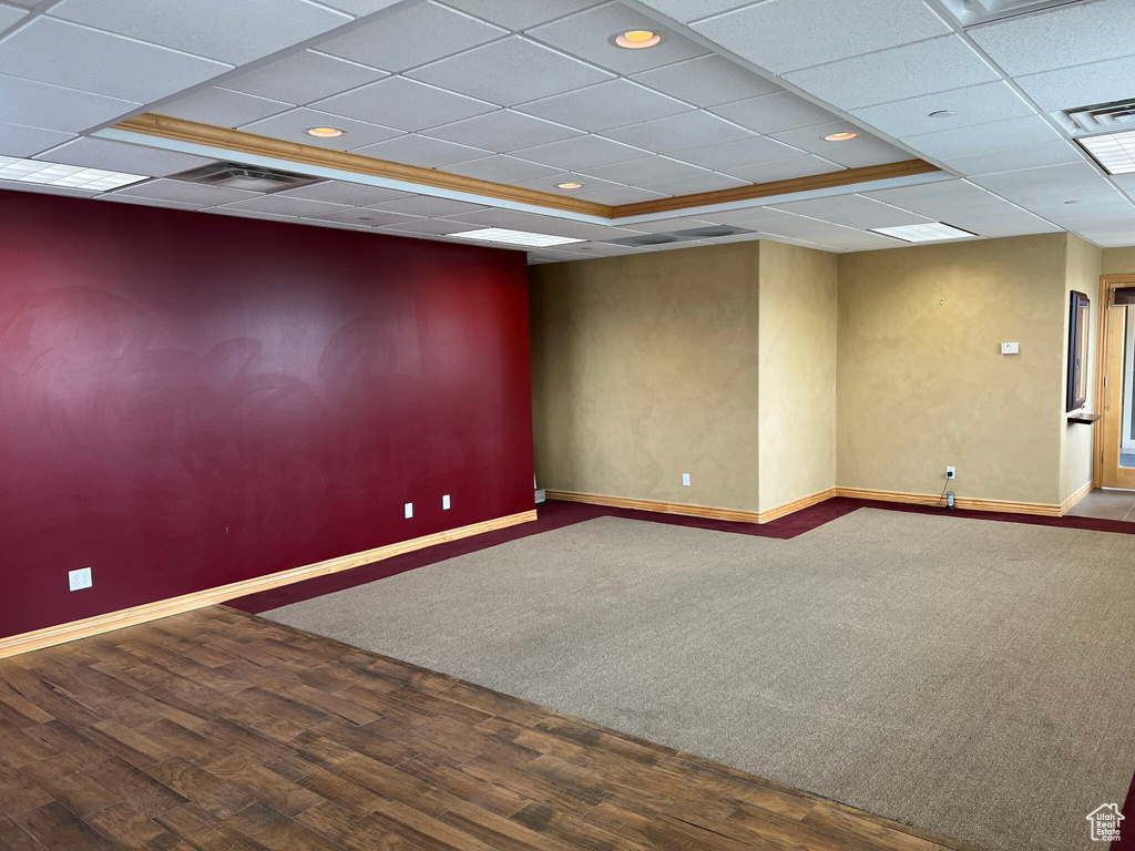 Unfurnished room with dark colored carpet and a paneled ceiling