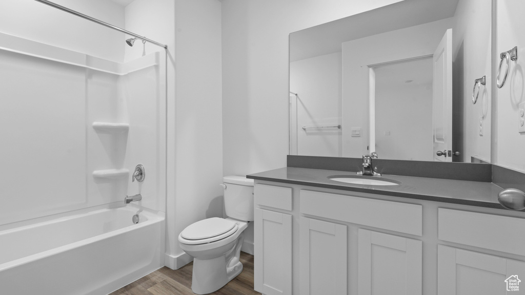 Full bathroom featuring shower / bath combination, hardwood / wood-style floors, vanity, and toilet