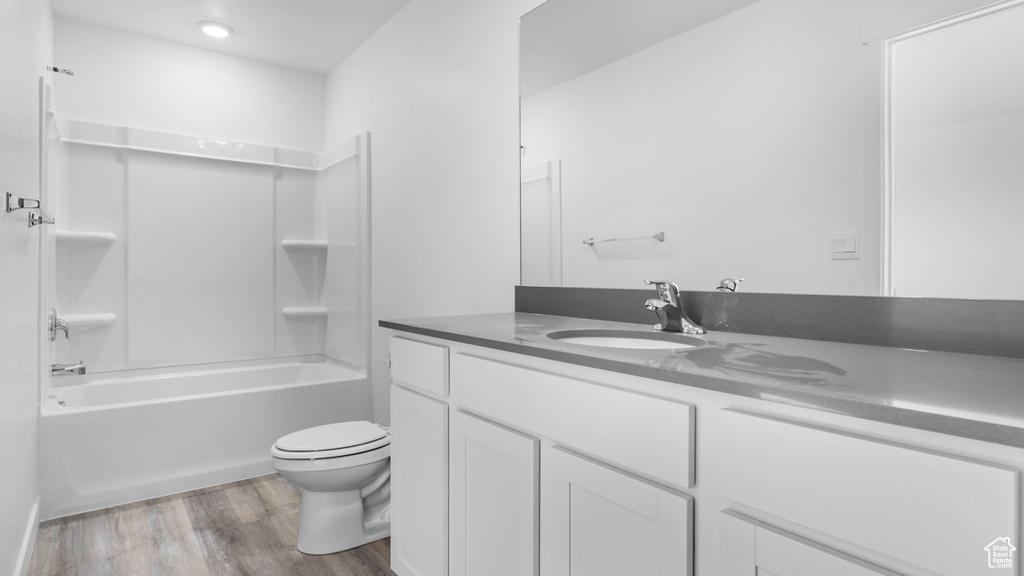 Full bathroom with toilet, vanity, hardwood / wood-style floors, and  shower combination