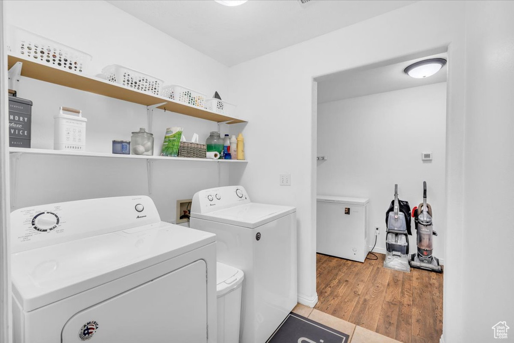 Washroom featuring washing machine and dryer, washer hookup, and light hardwood / wood-style flooring