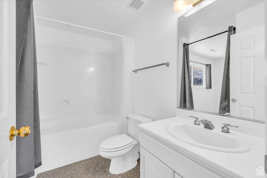 Full bathroom with toilet, shower / bath combination with curtain, and large vanity