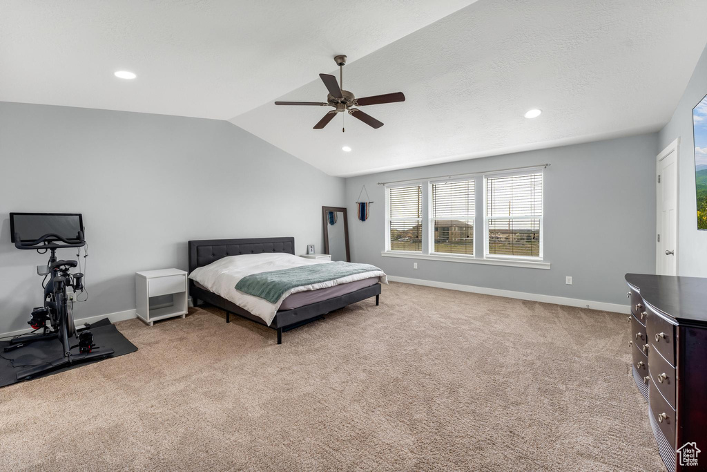 Bedroom with light carpet, vaulted ceiling, and ceiling fan