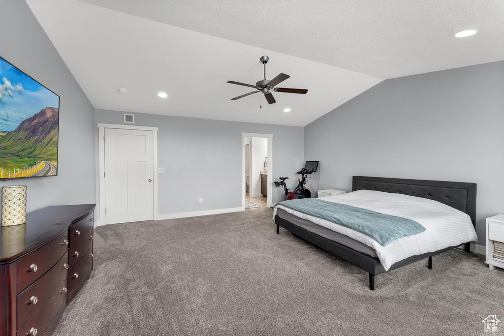 Carpeted bedroom with ensuite bathroom, ceiling fan, and lofted ceiling