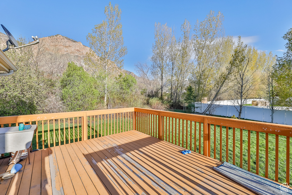 Wooden deck with a mountain view and a yard