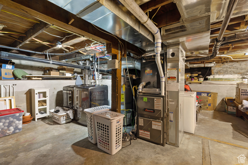 Basement featuring heating utilities and washing machine and clothes dryer