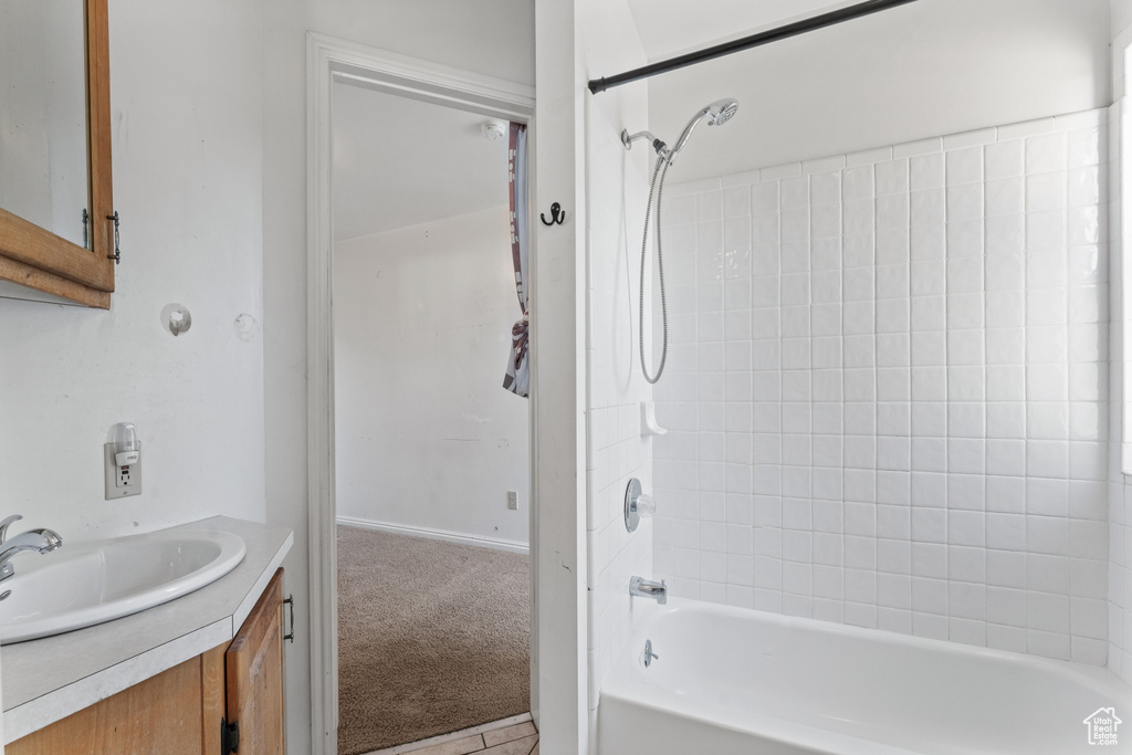 Bathroom with tiled shower / bath, tile floors, and vanity