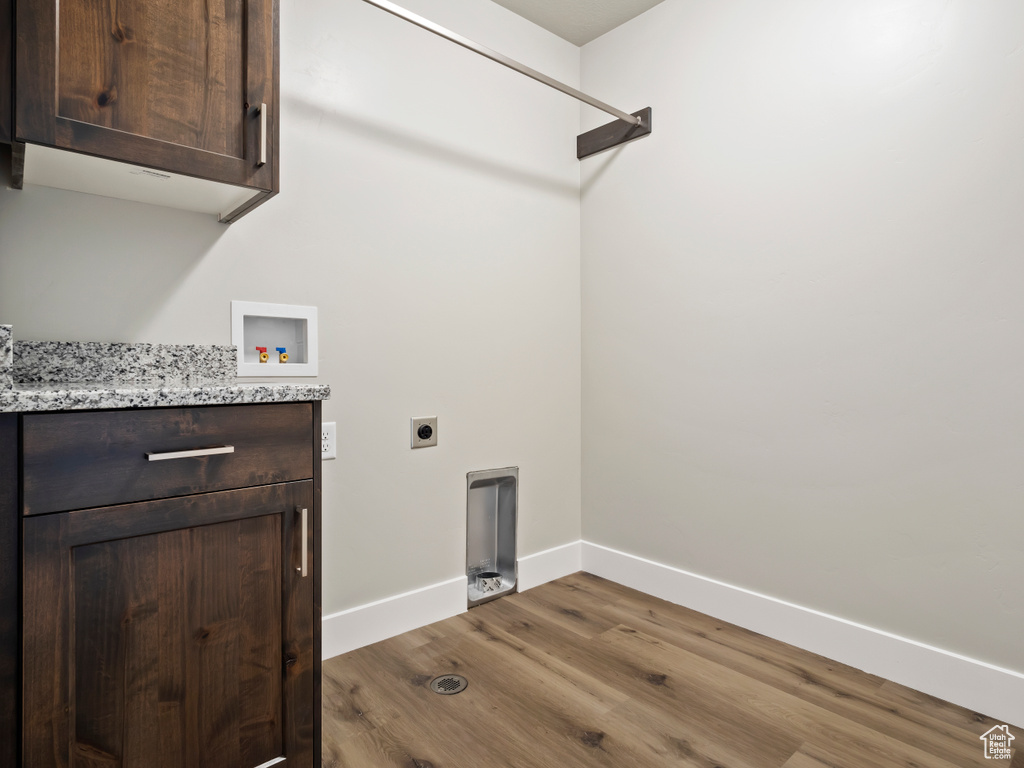 Laundry room featuring hookup for an electric dryer, dark hardwood / wood-style flooring, cabinets, and washer hookup