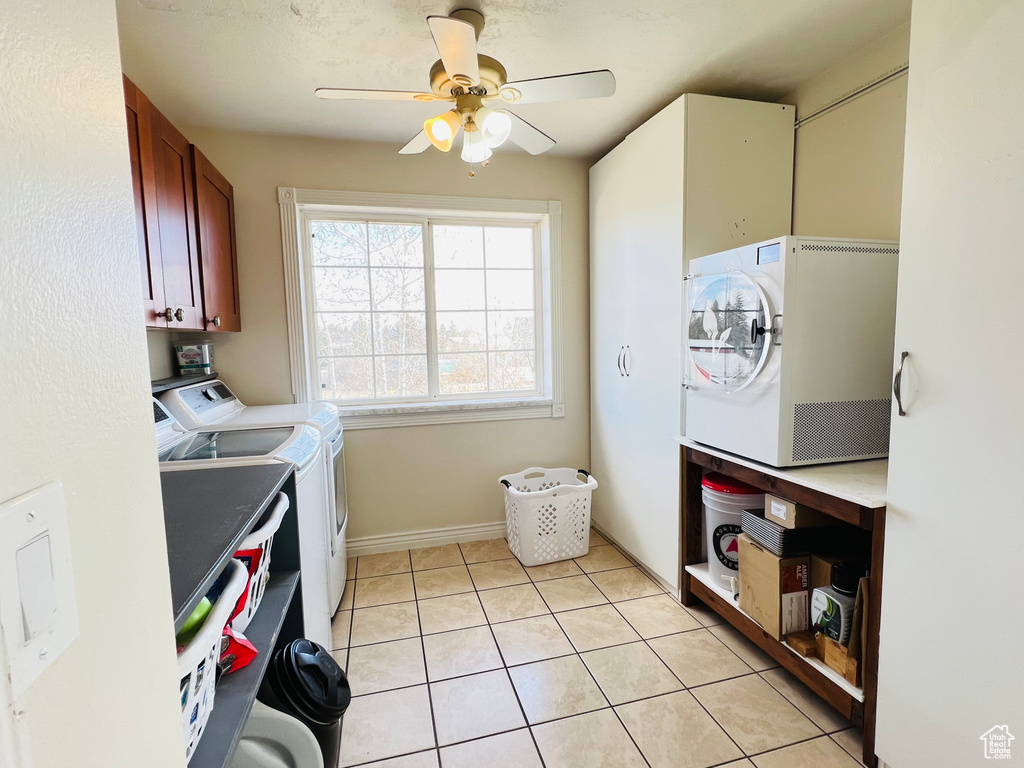 Laundry room featuring independent washer and dryer, cabinets, ceiling fan, and light tile floors