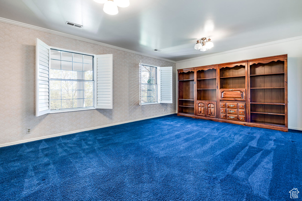 Interior space with ornamental molding and dark carpet