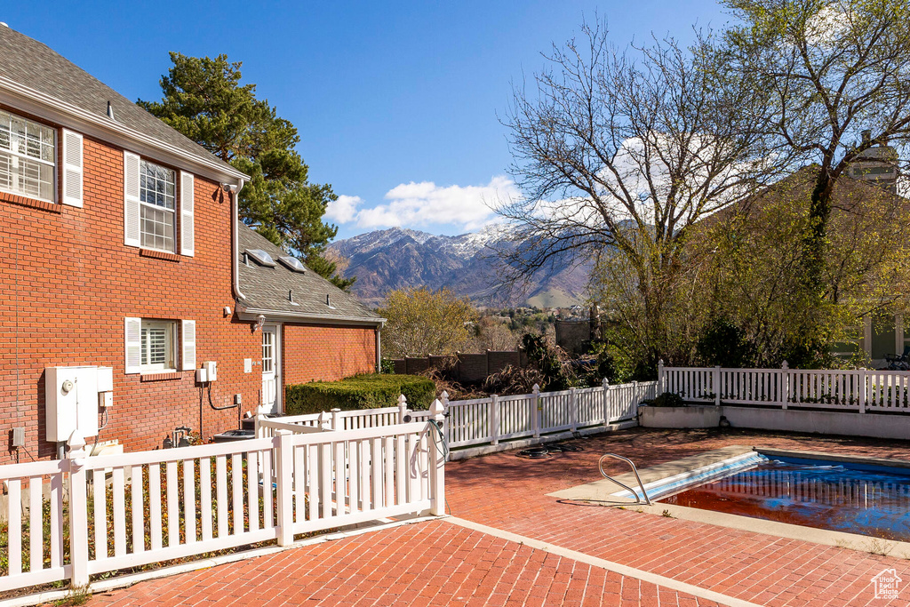 Exterior space featuring a patio, a mountain view, and a covered pool