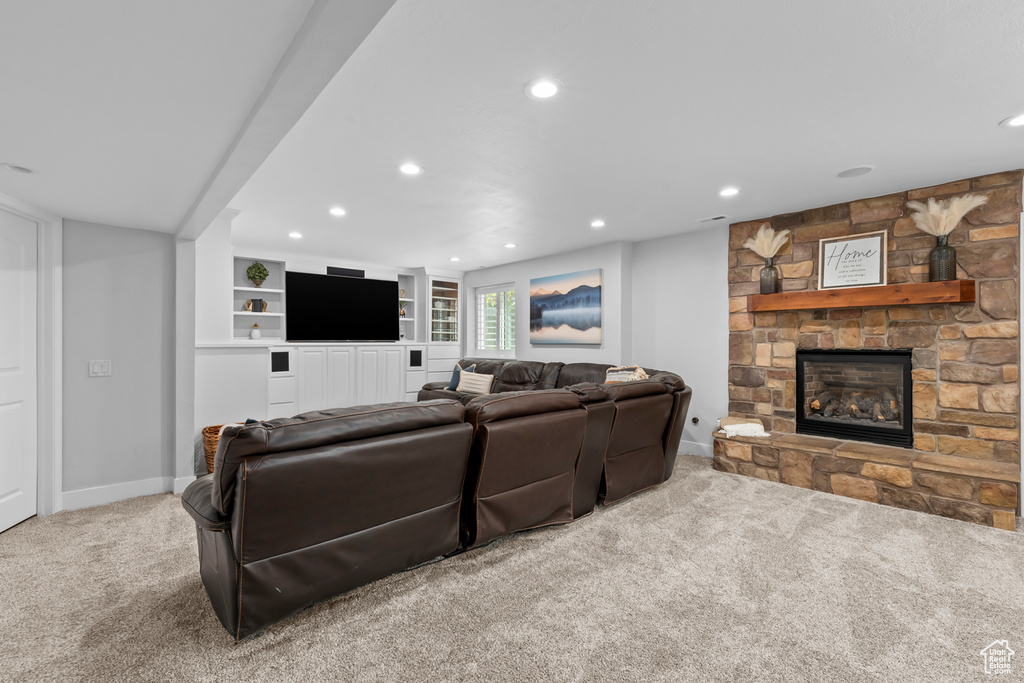 Carpeted living room with built in shelves and a fireplace
