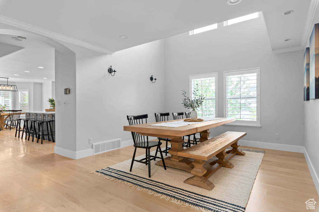 Dining space featuring ornamental molding and light hardwood / wood-style flooring