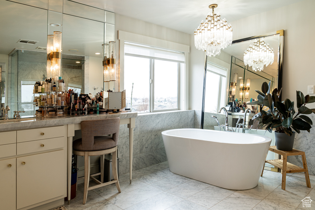 Bathroom featuring a chandelier, tile floors, a bathtub, and oversized vanity