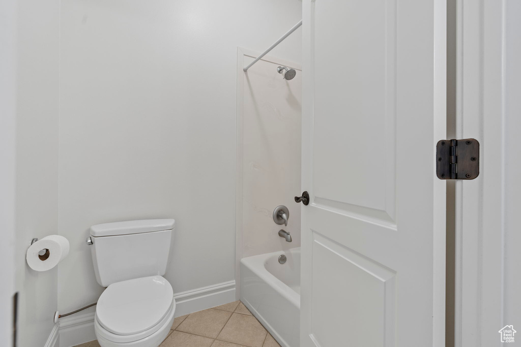 Bathroom with toilet, tile floors, and shower / tub combination