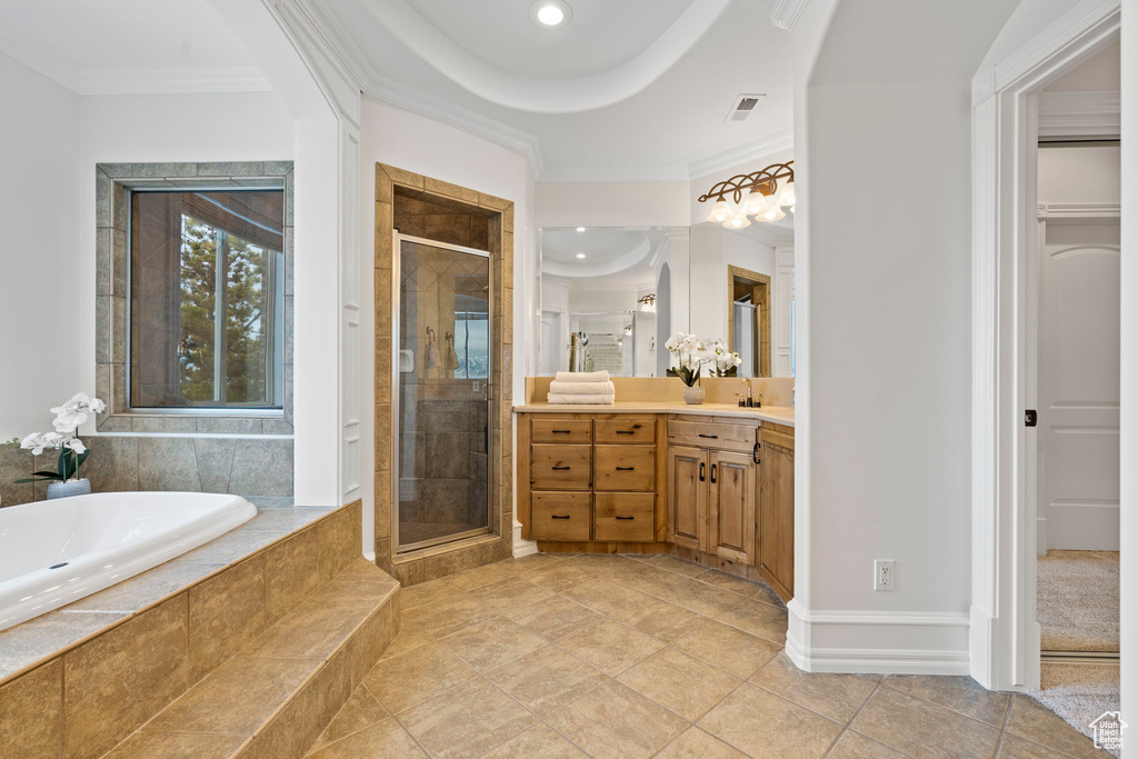 Bathroom featuring ornamental molding, oversized vanity, separate shower and tub, and tile flooring