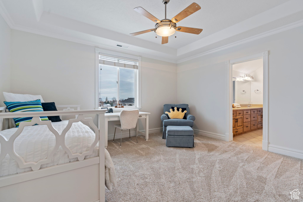 Bedroom with crown molding, ensuite bath, a raised ceiling, light colored carpet, and ceiling fan