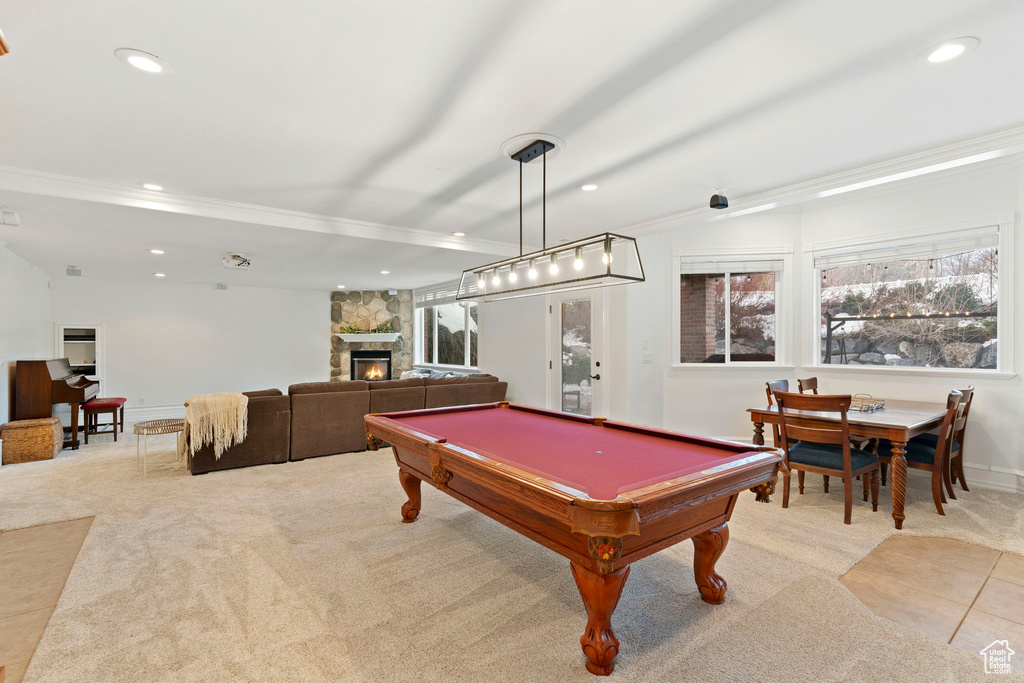 Game room featuring light carpet, ornamental molding, a fireplace, and pool table