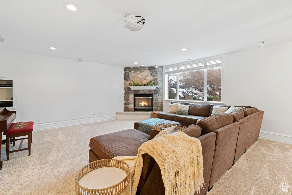 Living room featuring a stone fireplace and light carpet