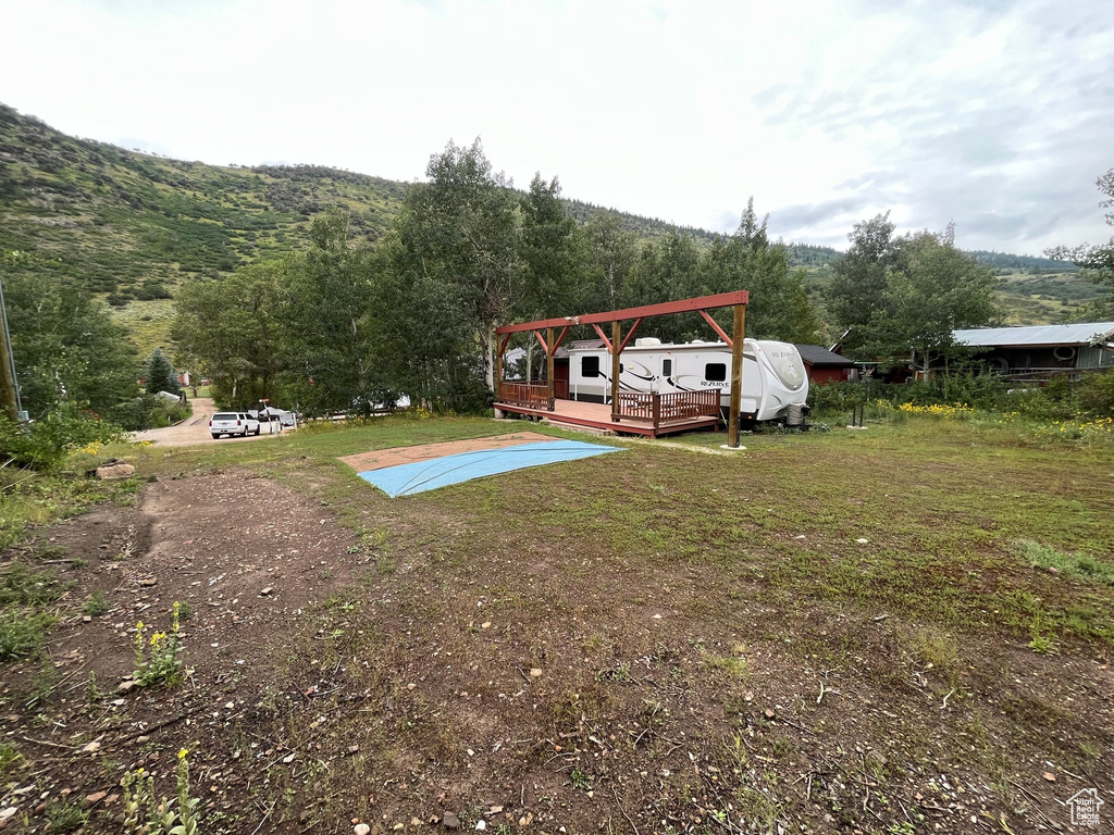 View of yard with a deck with mountain view