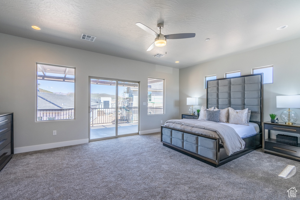 Bedroom with light colored carpet, ceiling fan, and access to exterior