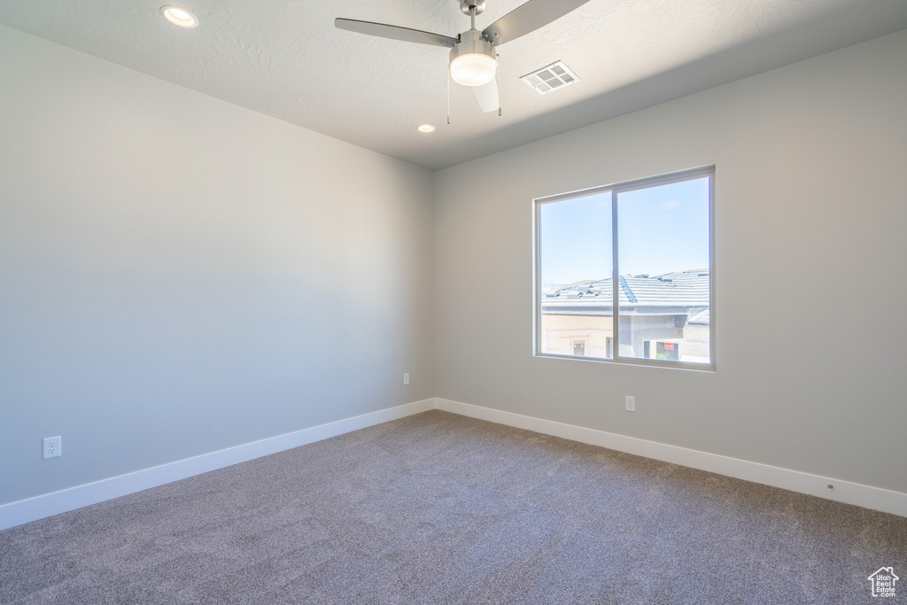 Spare room featuring ceiling fan and carpet floors