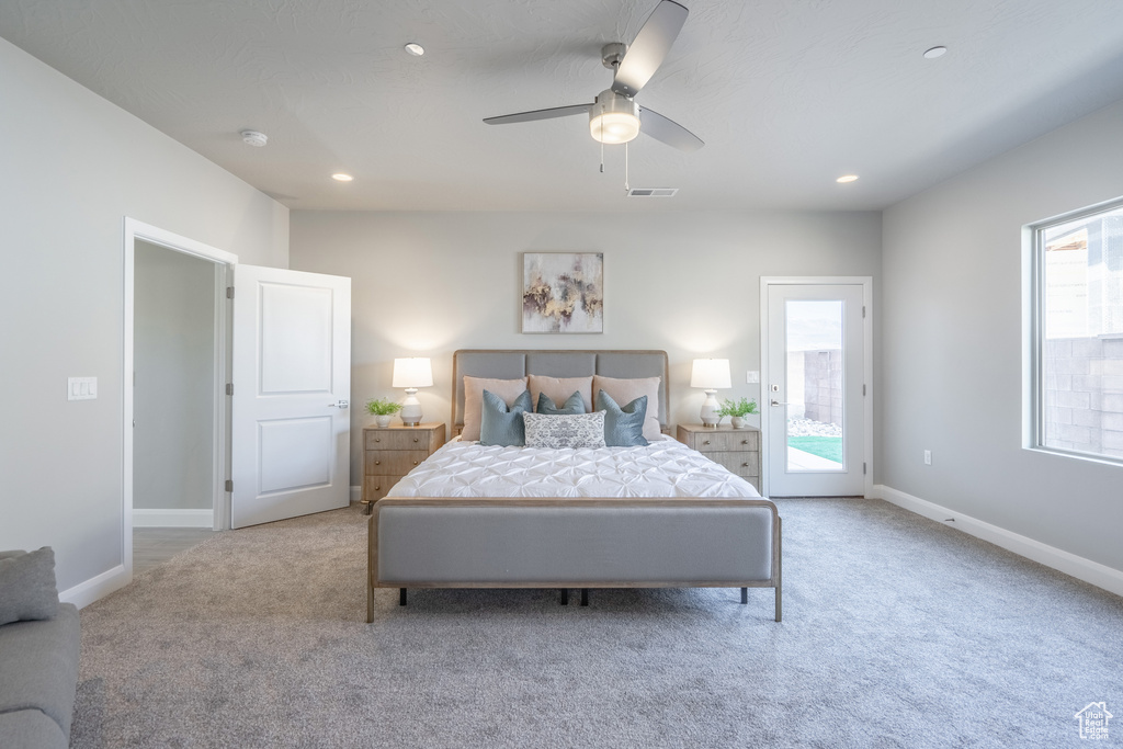 Bedroom featuring ceiling fan, light carpet, access to outside, and multiple windows