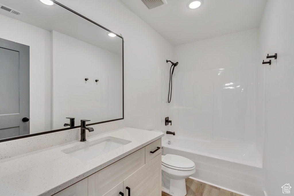 Full bathroom featuring wood-type flooring, bathtub / shower combination, vanity, and toilet