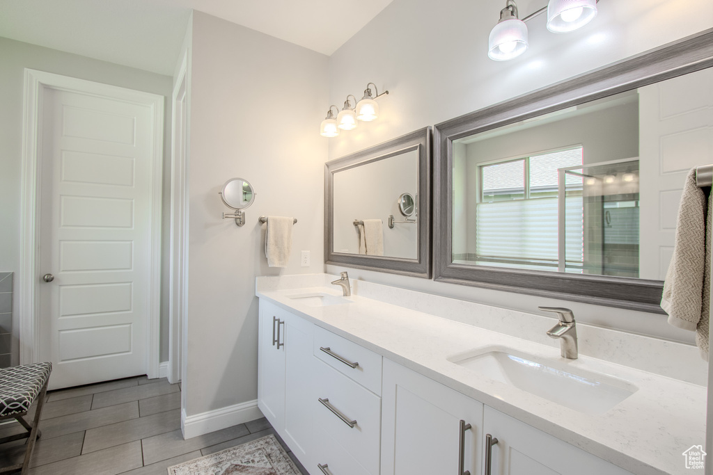 Bathroom with double vanity and tile flooring