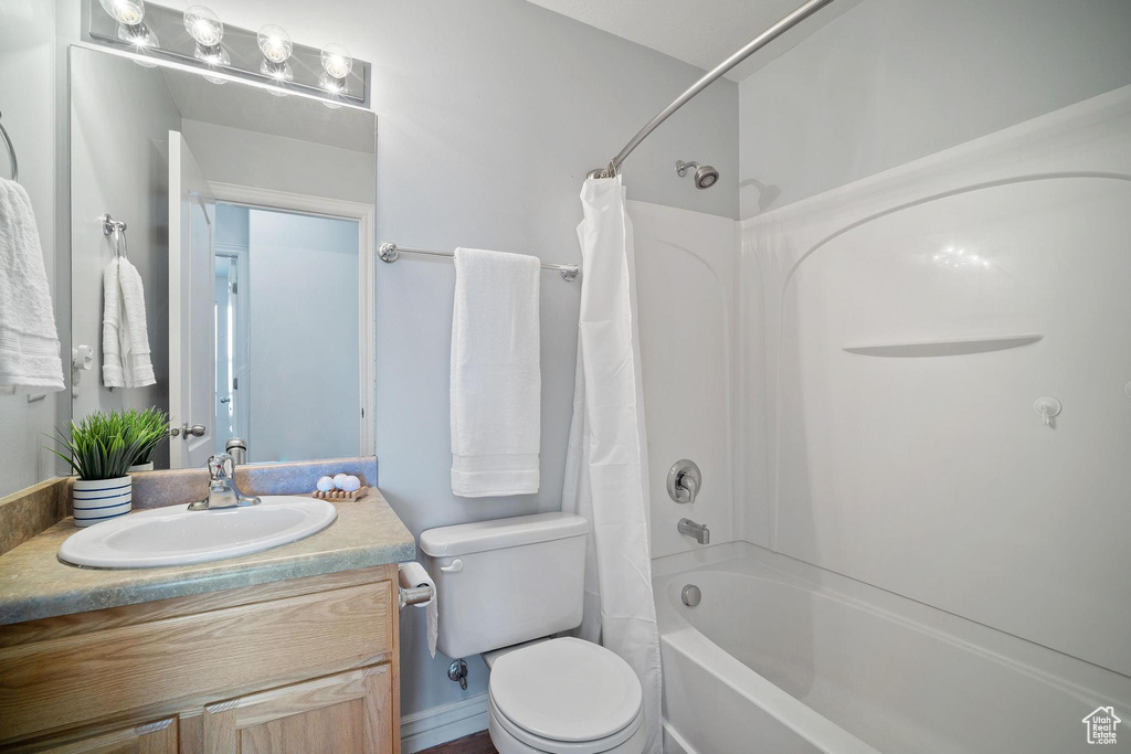 Full bathroom with shower / bath combination with curtain, toilet, and large vanity