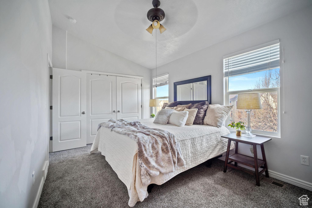 Carpeted bedroom featuring a closet, ceiling fan, and lofted ceiling
